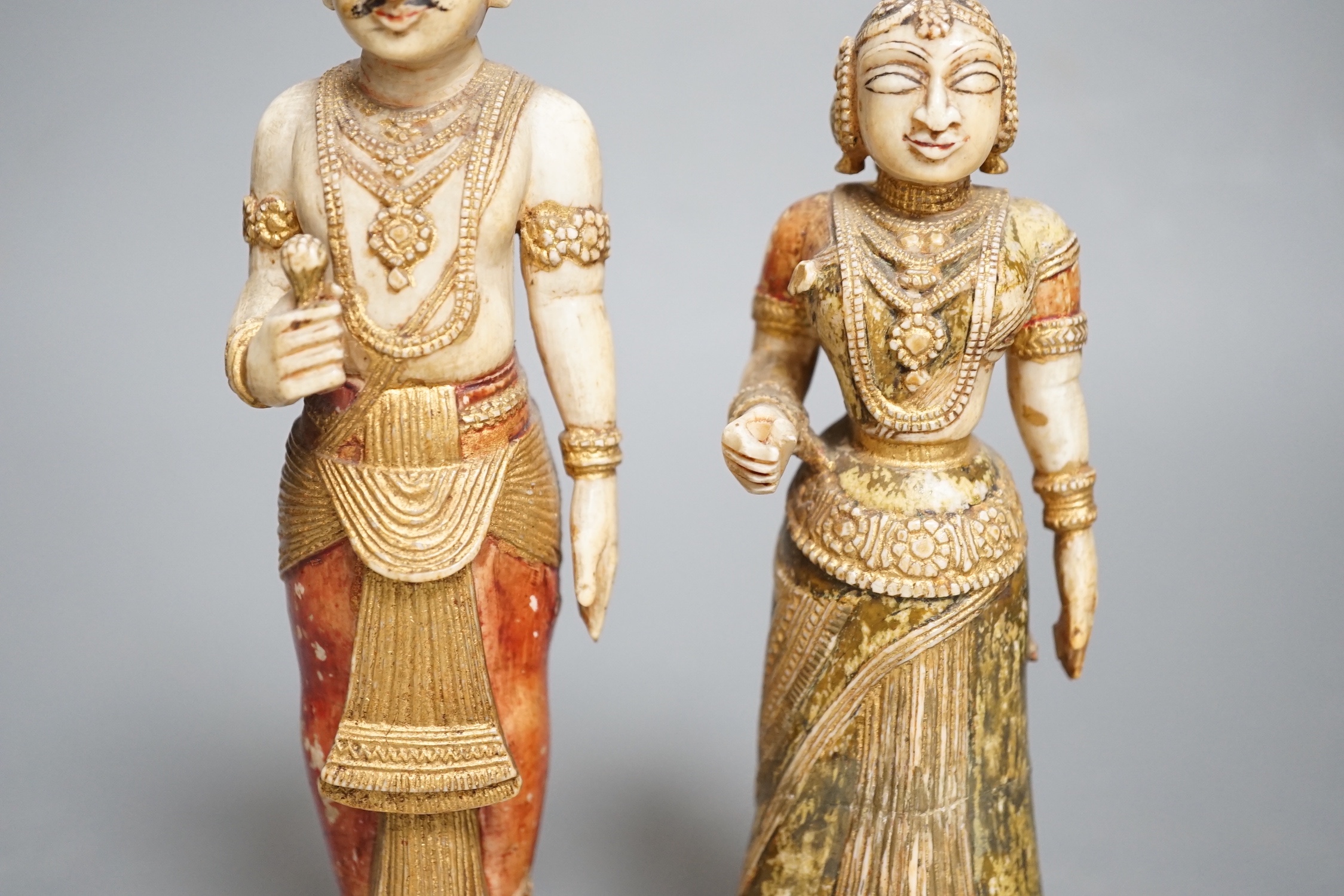 A pair of 18th century painted carved Indian ivory figures, male 7.6cm high female: 5.5cm high